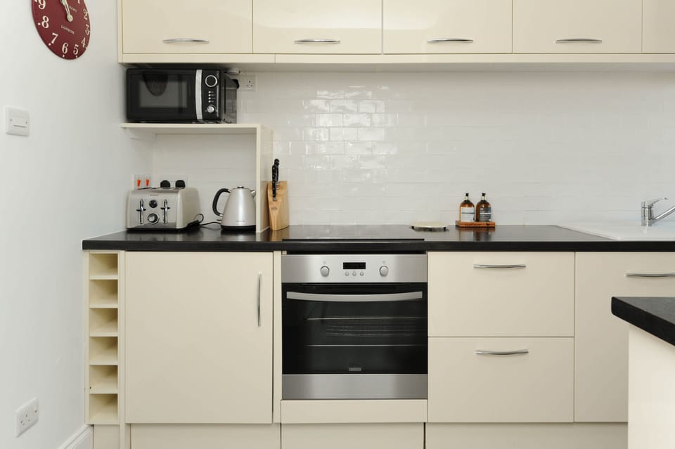 Fully equipped modern kitchen with dishwasher, hob, oven, fridge and cooking essentials