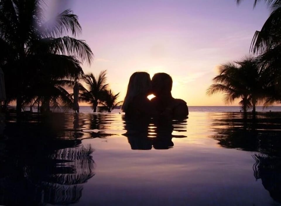 Having a romantic moment in the pool at sunset.