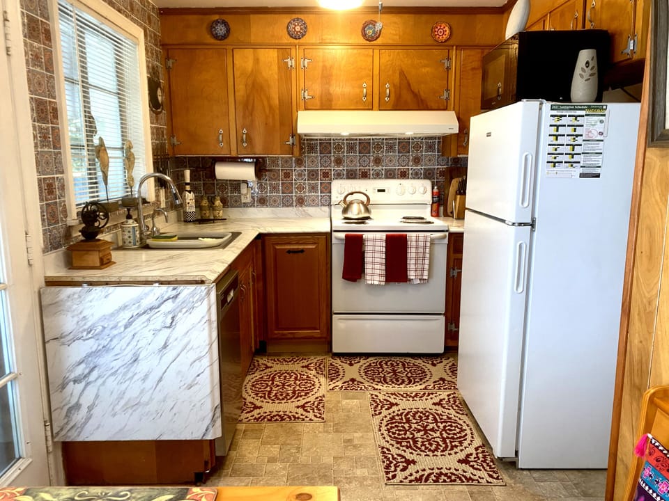 Classic 50’s full of cups, glasses, plates, bowls, & more pots and pans in stove