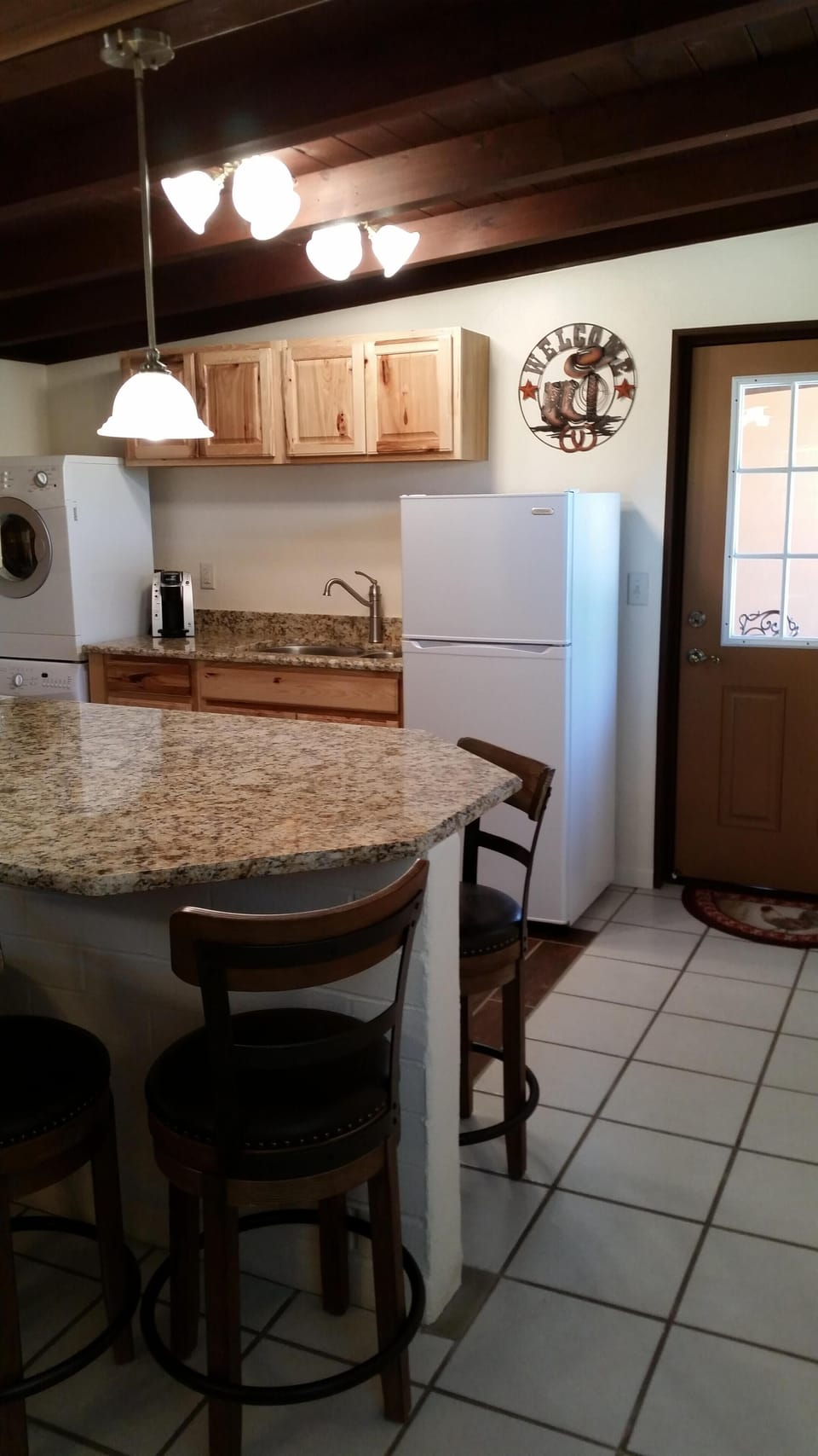 Kitchen with granite counters has seating for 4. 