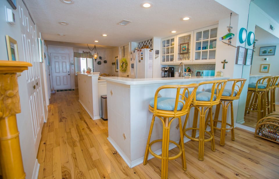 Hardwood floors, kitchen bar and bar stools.