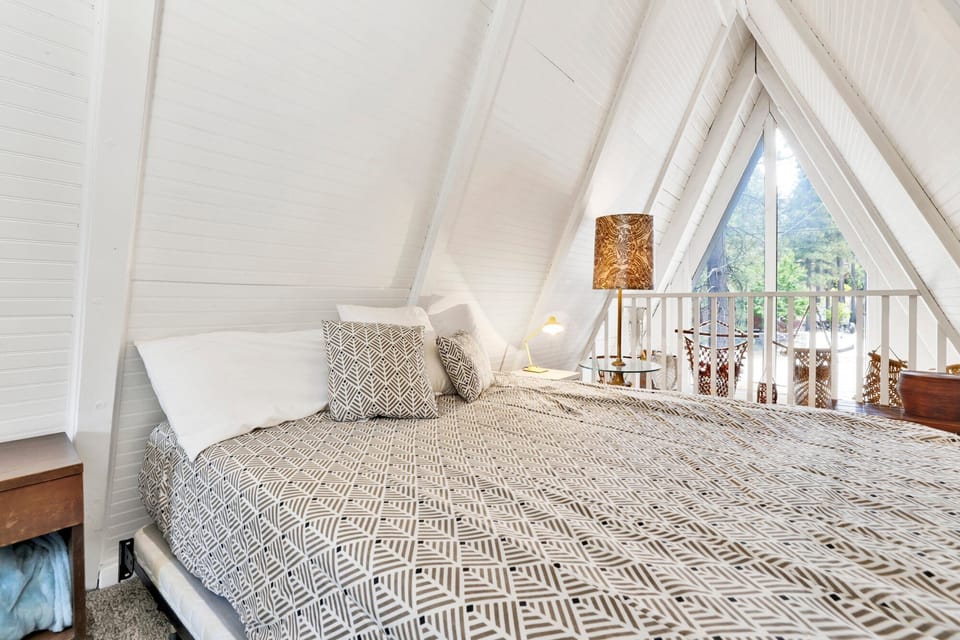 Peaceful cabin bedroom with plush bedding, and beautiful views—ideal for restful nights, cozy mornings, and a relaxing mountain escape.