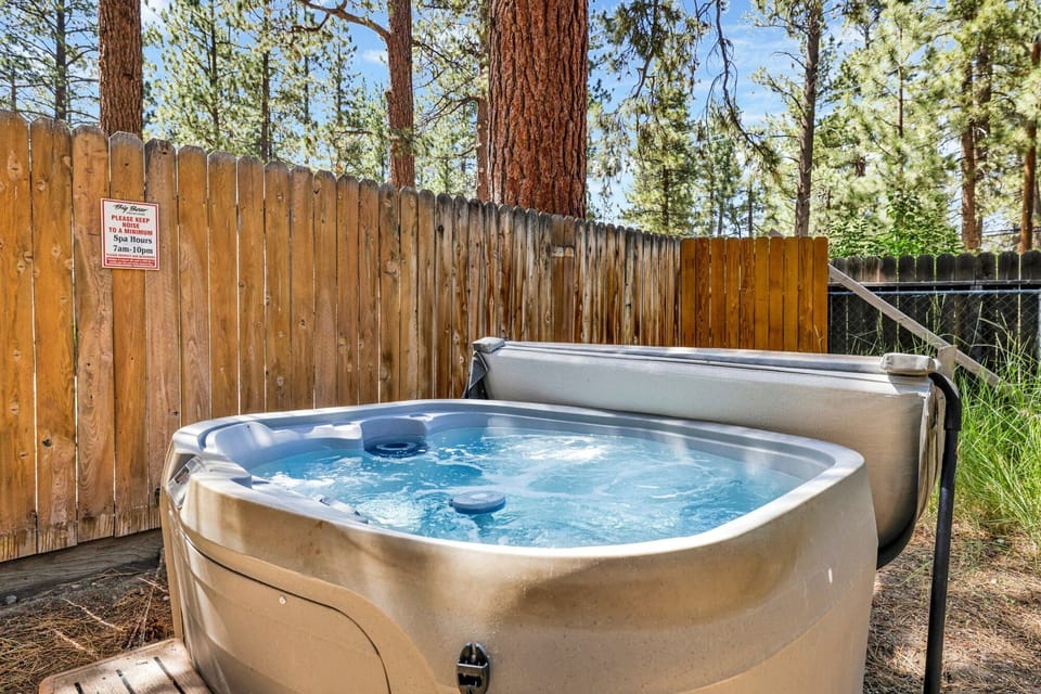 Private outdoor hot tub, surrounded by tall pines, perfect for relaxing under the trees after a day of adventure—enjoy peaceful forest views, fresh air, and a truly rejuvenating stay.