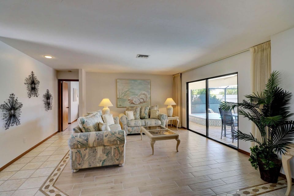 The sitting area provides a quiet place for conversation, while enjoying a view of the lanai, pool, spa, and canal.