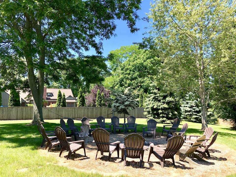OUTDOOR FIRE PIT:  behind pool fence, adirondack chairs, hammock, farmland views