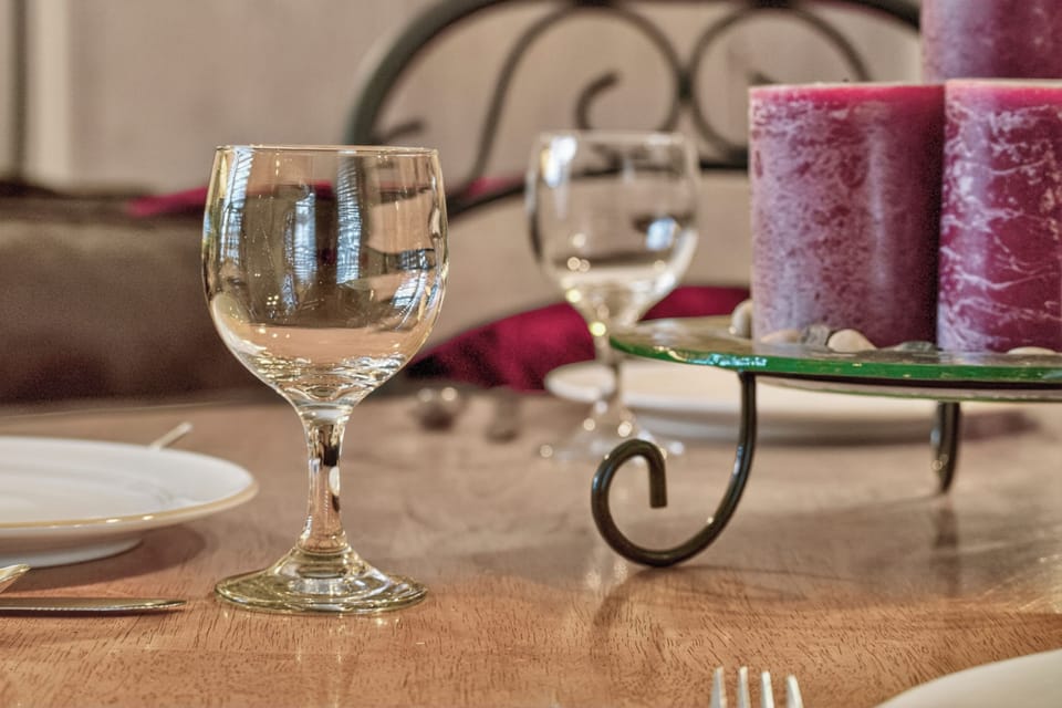 An elegantly set dining table awaits your arrival, complete with sparkling glassware and decorative candles creating a warm, intimate atmosphere perfect for memorable meals.