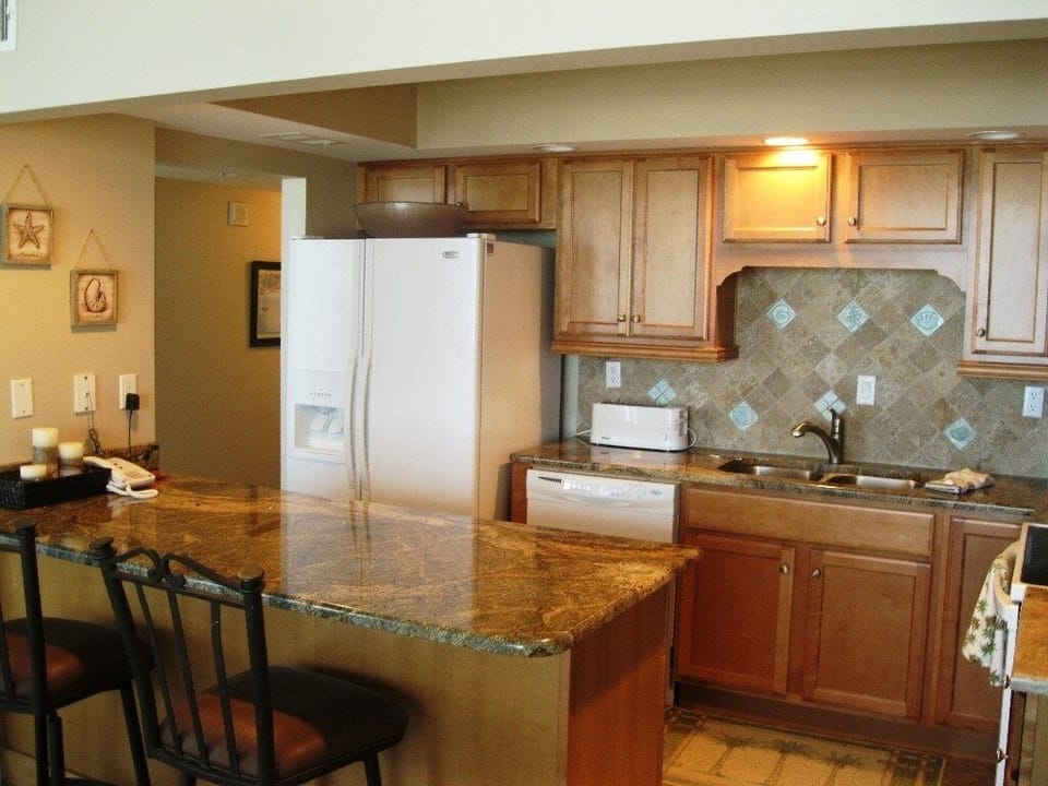 Kitchen view with granite counter tops and decorative tile back splash.
