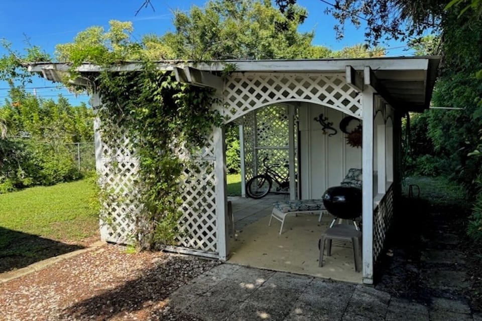 Outdoor patio with charcoal grill, 2 cruiser bikes and lounge chairs