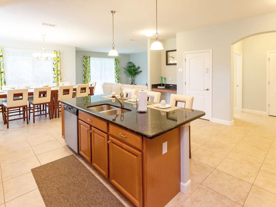 The kitchen island features two sinks and a faucet with seating for three.