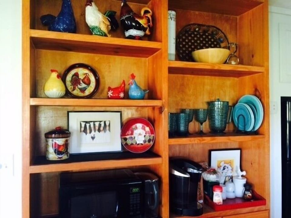 Kitchen shelves with chicken collection, microwave, and Keurig coffee pot.
