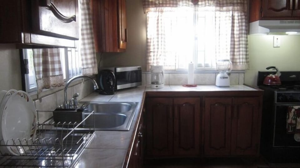 fully equipped kitchen area with water and backyard views