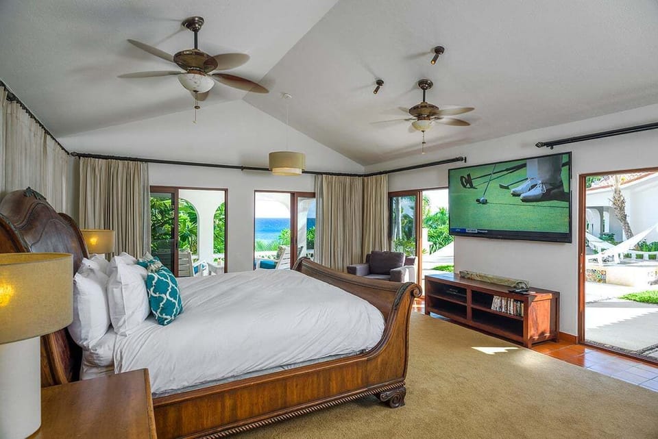 Ocean-view en-suite bedroom with wall-mounted television at Casa Edwards, Palmilla, Los Cabos