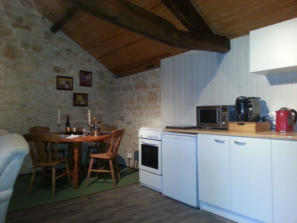 Kitchen and Dining Area with gas oven and hob, coffee maker, kettle & microwave.