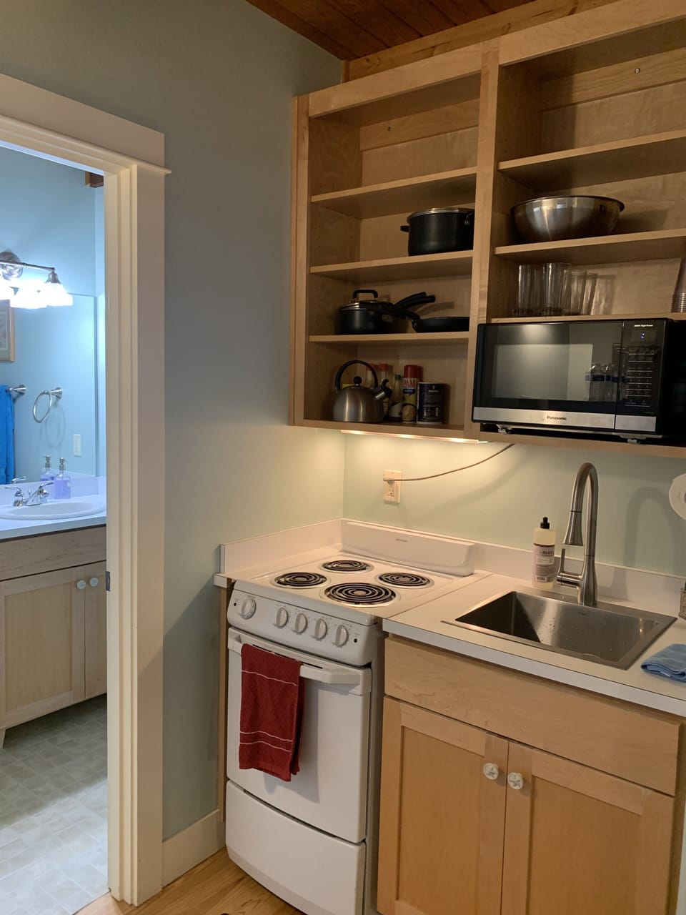 Kitchenette with refrigerator, cooktop, oven, sink, microwave oven