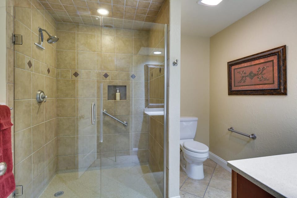 En-suite bath with handicap shower, toilet, and sink