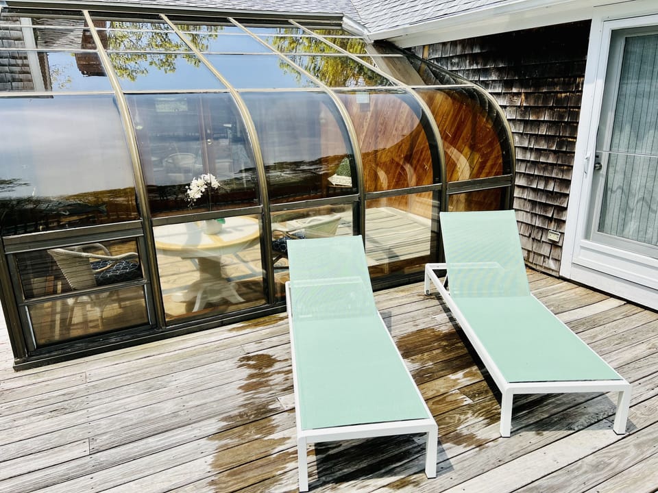 New lounge chairs by the pool in front of sunroom. 