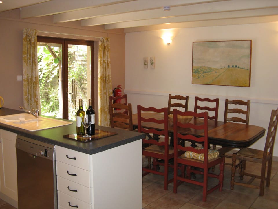Kitchen and dining area in La Grange with doors opening onto the courtyard