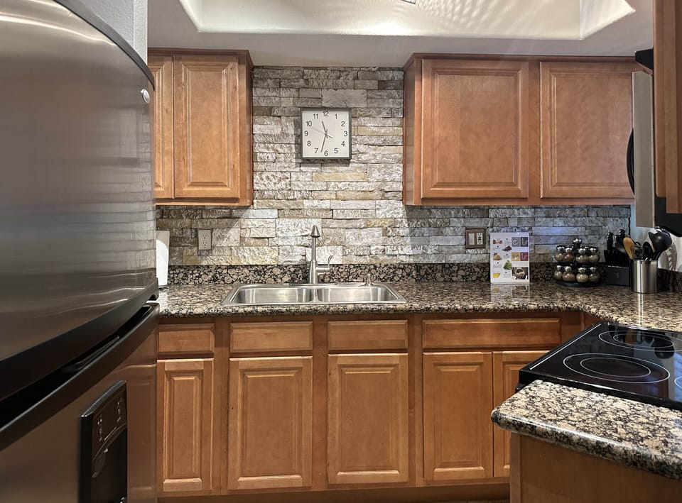 Kitchen has fridge, stove, oven, microwave, dishwasher, electric grill, spices