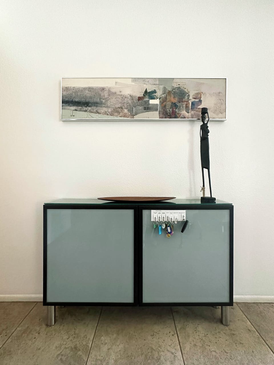 View of the entrance way/dining side cabinet and keys