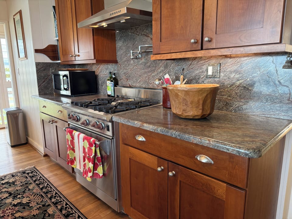 Wolf gas range, cherry cabinets and rainforest granite countertops. It's nice. 