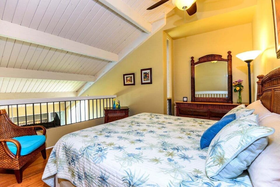 Loft bedroom with wooden furniture and ceiling fan