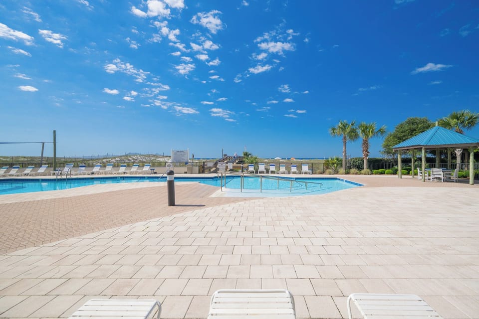 Enjoy the inviting pool area surrounded by lush greenery and comfortable lounge chairs for a relaxing day in the sun