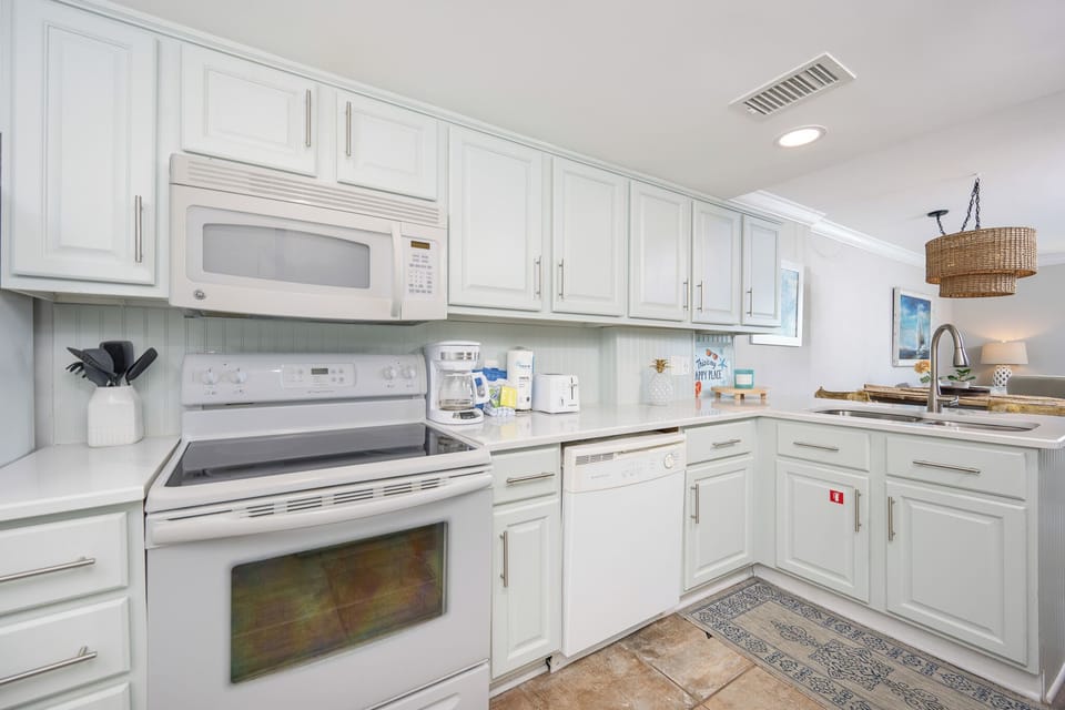 Spacious kitchen featuring modern appliances, white cabinetry, coffee maker, and a cozy vibe perfect for family meals