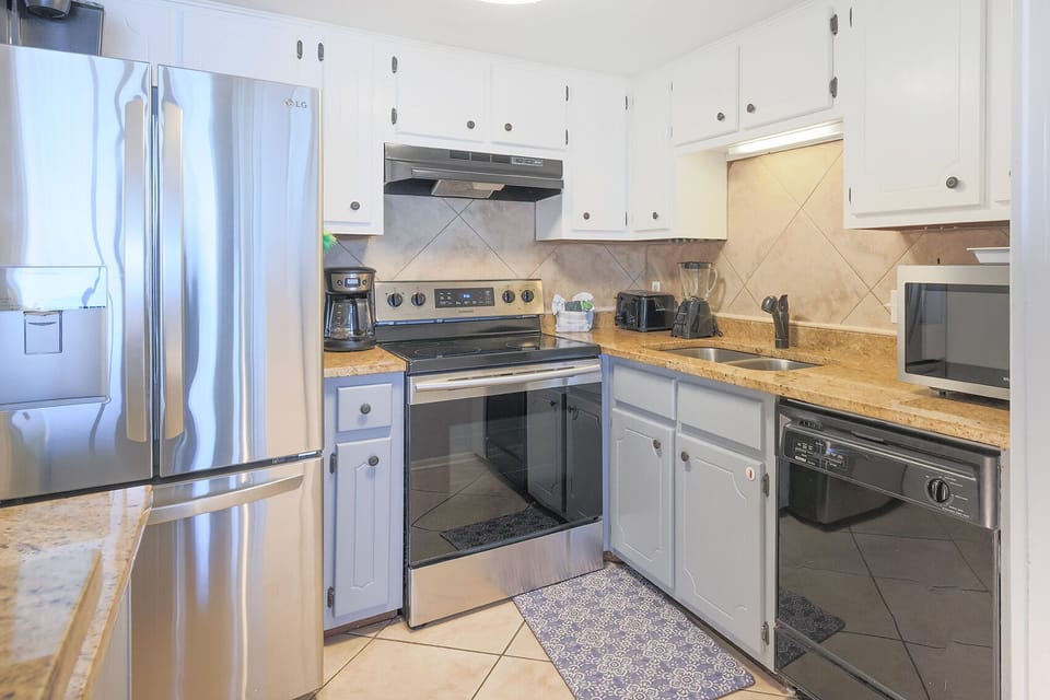The kitchen features stainless appliances, granite countertops, and ample cabinetry for a delightful cooking experience