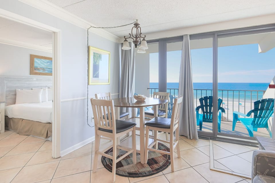 This inviting dining area features a round table and stunning beachfront views, perfect for enjoying meals and relaxation