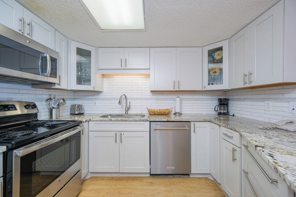 Whip up fresh coastal meals with ease in your bright kitchen featuring sleek appliances and cool tile backsplash