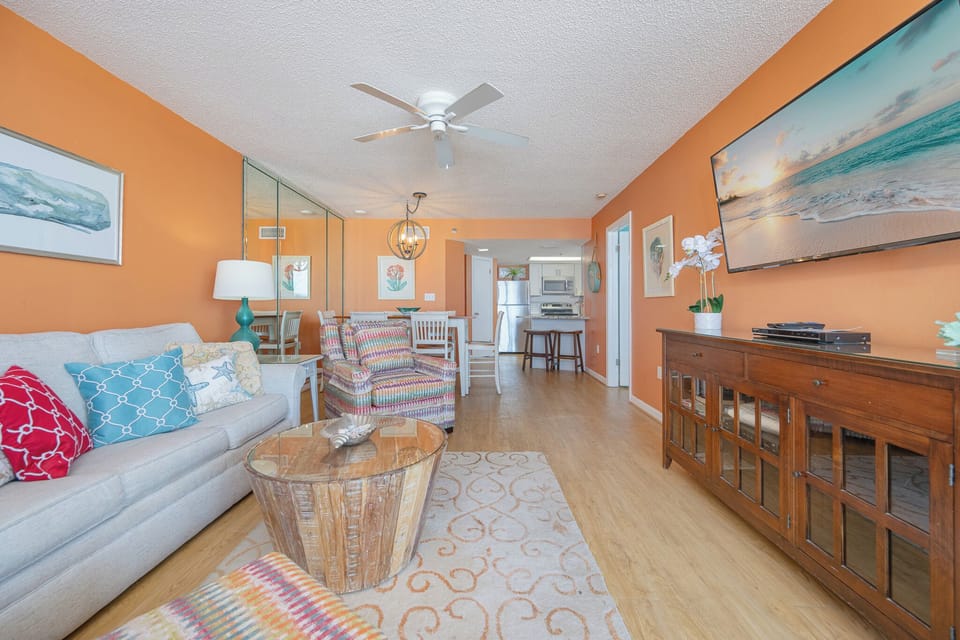 The living room wraps you in cozy color and texture while you unwind with favorite shows after fun beach days