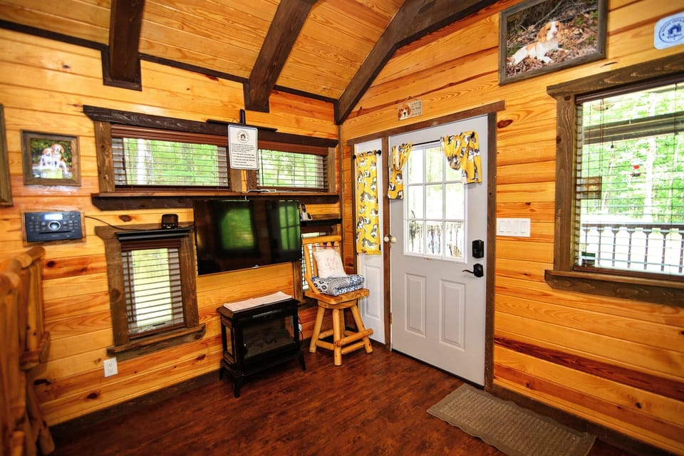 - Cozy cabin entry with warm wood walls and natural light   - Forest getaway living area featuring TV and heater   - Inviting retreat designed for relaxing cabin stays