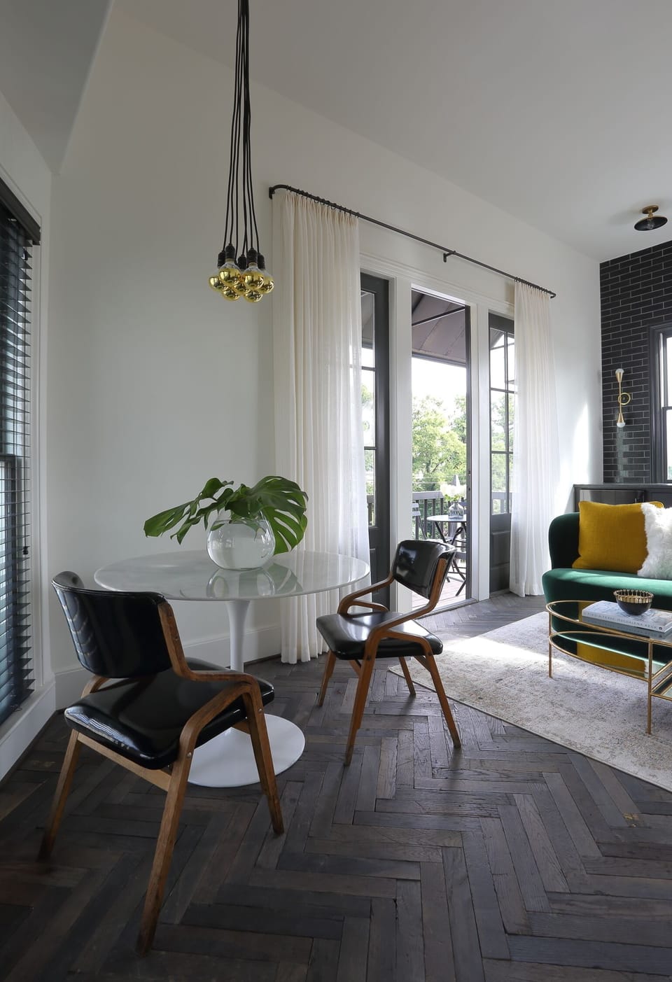Dining with reclaimed factory herringbone flooring and mid-century antique chair