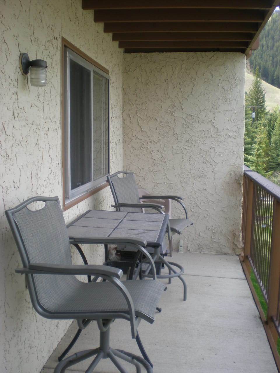 Balcony with seating, small propane grill and view of the mountain.