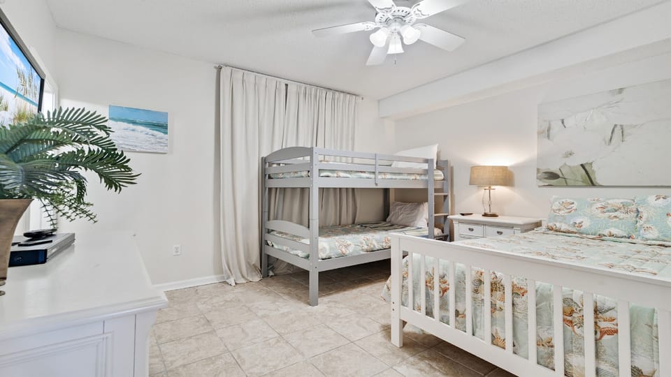 Versatile full size bed+ bunk bed room offering comfortable accommodations for guests or family. This space maximizes functionality and style, providing a cozy and inviting atmosphere.