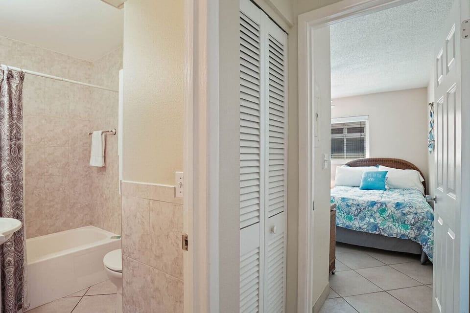 Convenient condo bathroom with a bathtub and shower combination, located next to the comfortable bedroom.