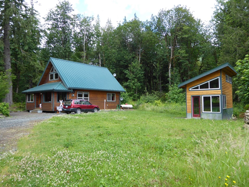 View of both cabins as you enter the private property, lots of trees,lawn, park.