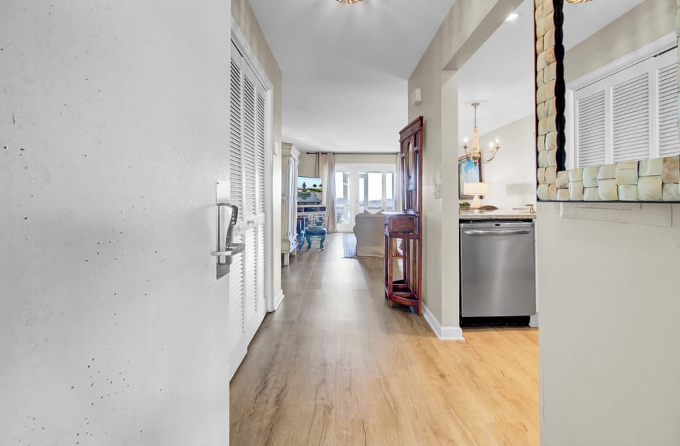 Step into your bright, open-concept space where elegant hardwood flows seamlessly from kitchen to living area, creating the perfect backdrop for your coastal getaway.