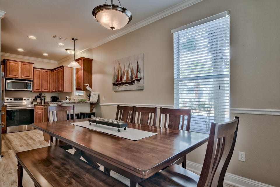 Spacious dining area featuring a large 8–9-seater coastal table, with a kitchen bar for two.