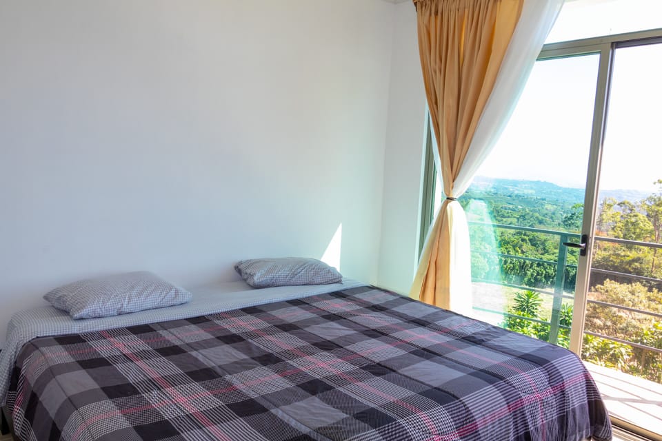 Master bedroom with king sized bed and balcony.