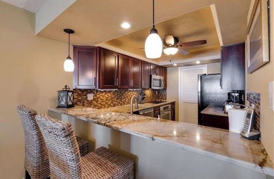 Kitchen with granite countertops and built in cooktop stove and oven. 