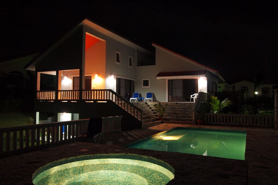 pool deck with the back view of the villa at night