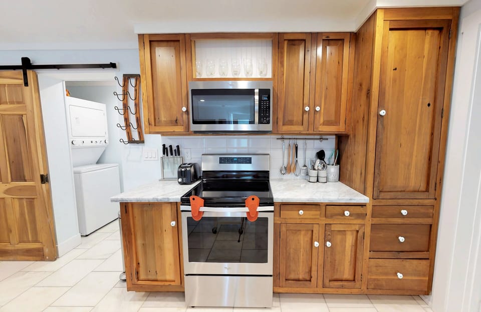 Marble Counter and Stainless Appliances with Barn Door to Private Laundry