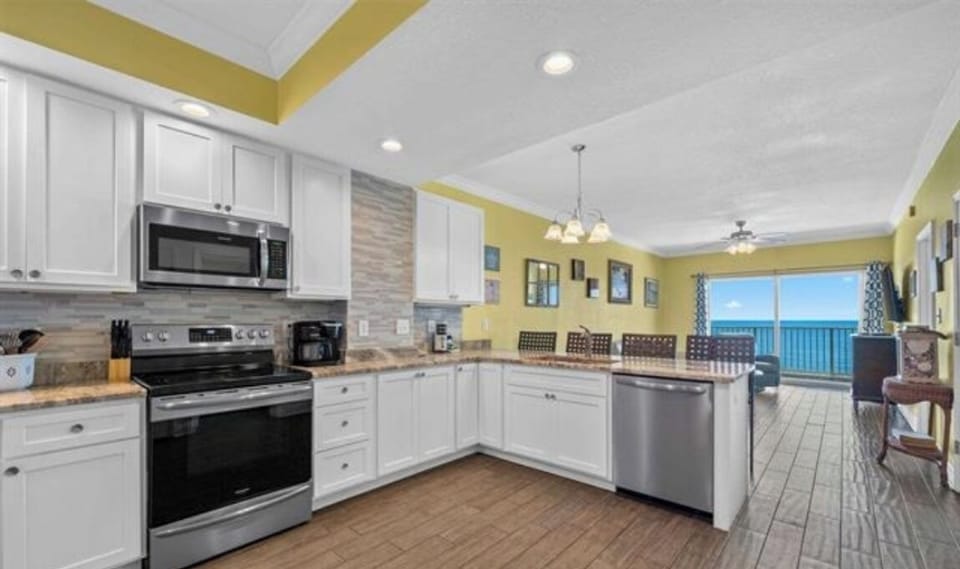 ENLARGED kitchen with stainless steel appliances (electric range, above range microwave, dishwasher, fridge with ice maker, solid wood cabinets, granite countertops and tiled backsplash