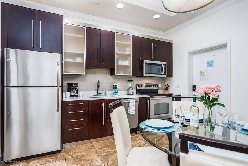 Full updated kitchen stocked with dishes, pots and pans, with dining table for 4.