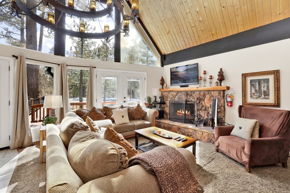 Cozy mountain living room with a stone fireplace, comfy seating, and smart TV—perfect for relaxing evenings, movie nights, and warm cabin vibes after outdoor adventures.