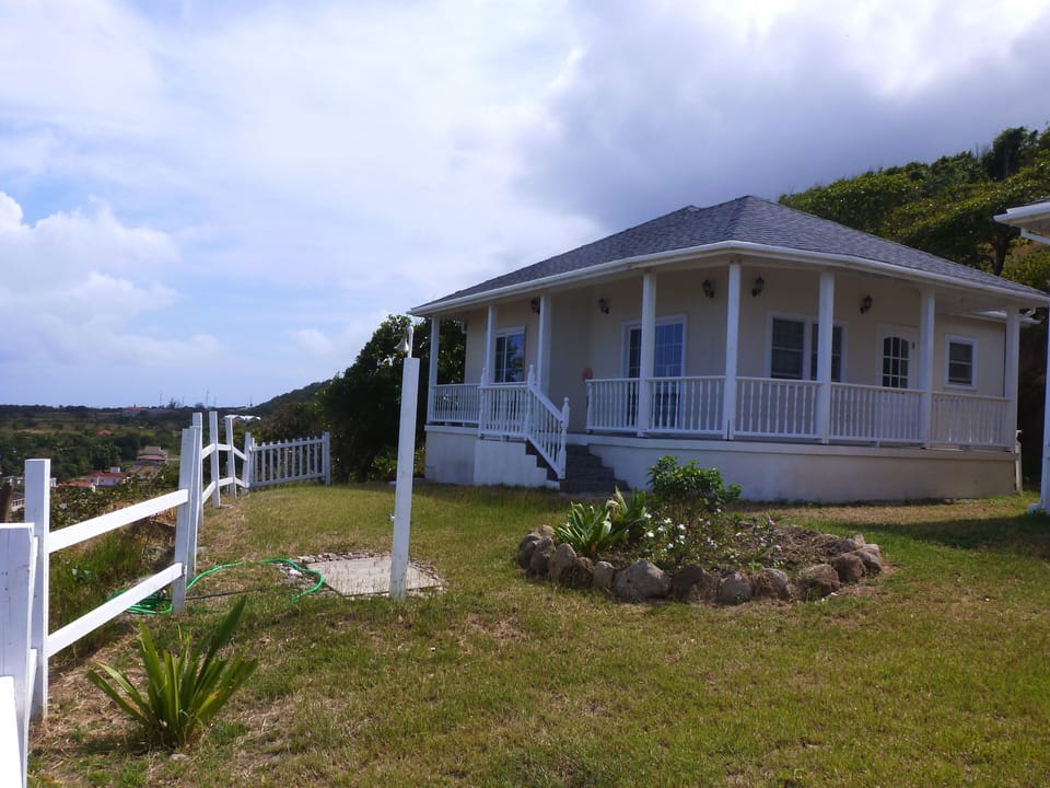 Seagrape Heights 2 bedroom cottage showing outdoor shower and flower garden