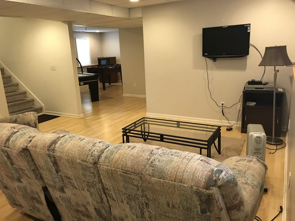 finished walk out basement  w recliner, couch and air hockey & foosball tables
