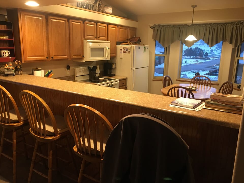 Beautiful kitchen and bar area with 4 tall bar stools.