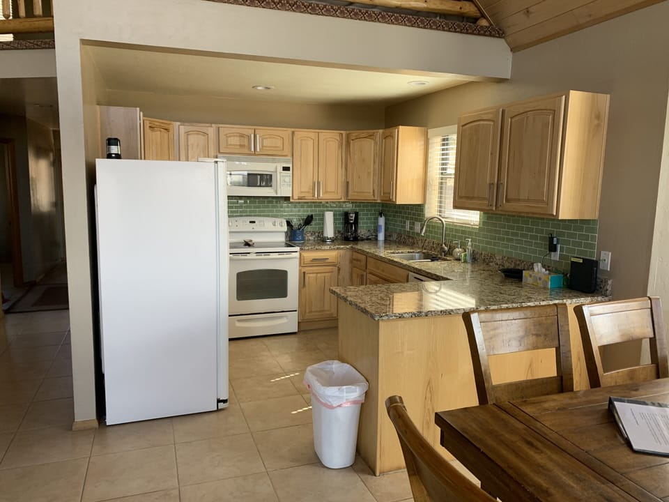 Kitchen with all cooking amenities, fridge with ice maker.
